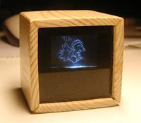 A photo of a wooden cube, displaying an adorable creature.